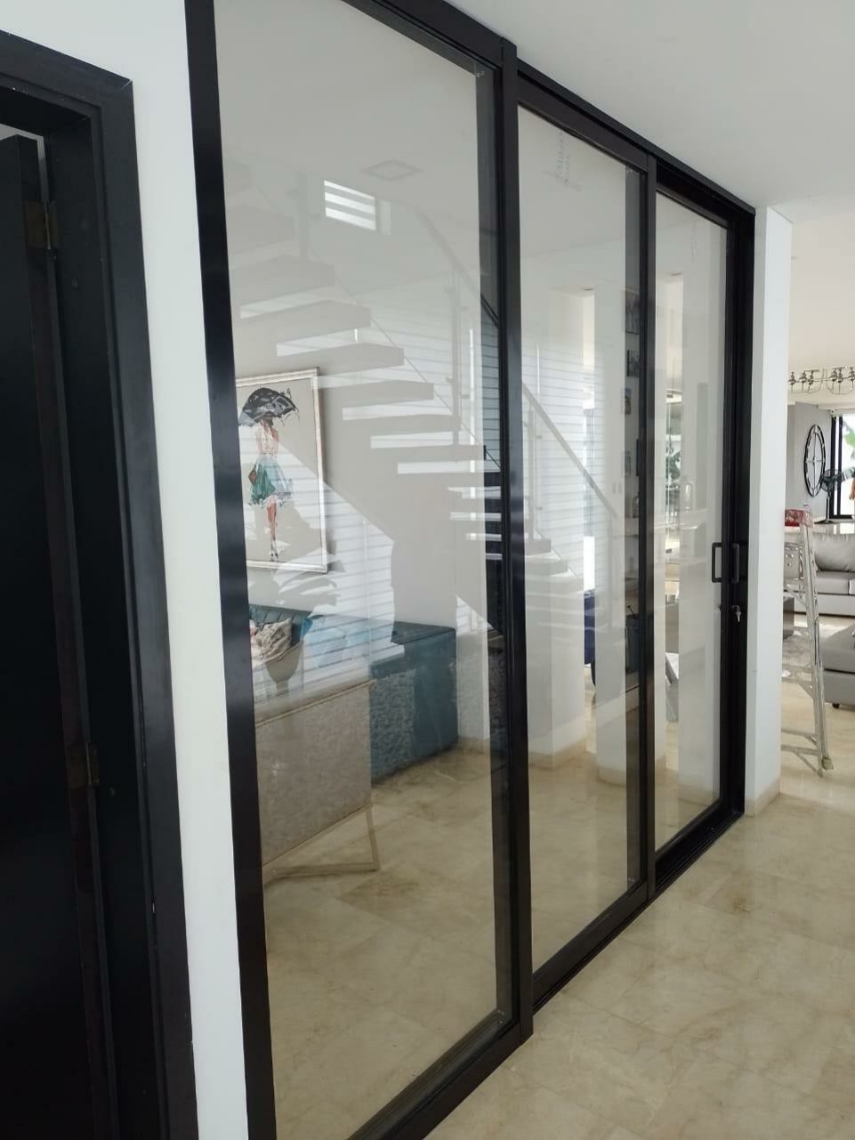 Puerta corrediza de vidrio con perfilería negra tipo industrial